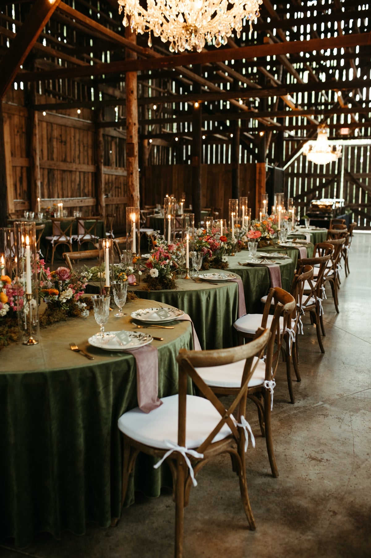 Candlelit barn wedding reception with green velvet tables and wildflowers at a Nashville wedding by Lizzy Oakley
